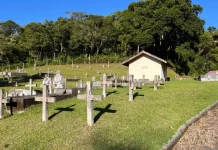 São José interdita três estabelecimentos funerários e abre credenciamento para novas empresas Cemitério com cruzes no chão ao lado das sepulturas, ilustrando os serviços funerários em São José.