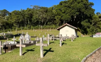São José interdita três estabelecimentos funerários e abre credenciamento para novas empresas Cemitério com cruzes no chão ao lado das sepulturas, ilustrando os serviços funerários em São José.