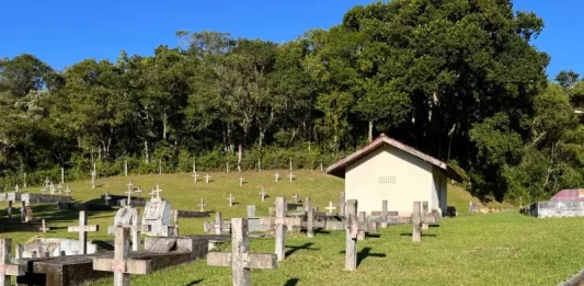 São José interdita três estabelecimentos funerários e abre credenciamento para novas empresas Cemitério com cruzes no chão ao lado das sepulturas, ilustrando os serviços funerários em São José.