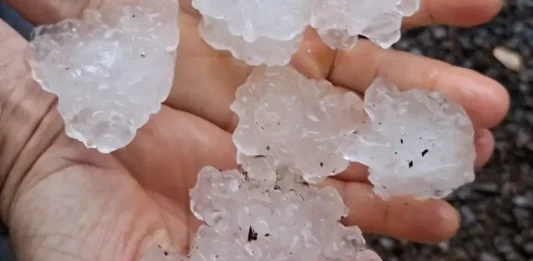 Chuva intensa e granizo causam danos em 23 municípios de Santa Catarina Mãos segurando pedras de granizo após chuva intensa em Santa Catarina