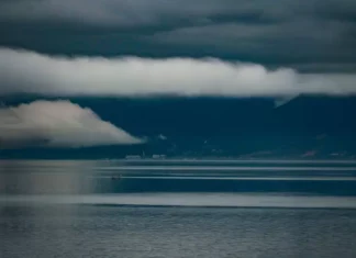 El Niño deve trazer chuva acima da média para SC na primavera, aponta Fórum Climático Foto do mar sob céu carregado de nuvens escuras e tempestade, com montanhas ao fundo, ilustrando a previsão do Fórum Climático de chuva acima da média e maior frequência de tempestades severas em Santa Catarina.