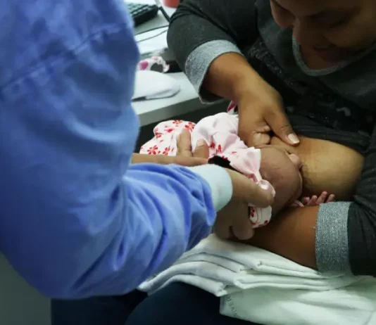 São José promove curso de amamentação nesta sexta-feira durante o Agosto Dourado Foto de mãe amamentando criança com auxilio de enfermeira, simbolizando o curso de amamentação dutrante agosto dourado