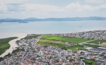 População de Biguaçu chega a 85.472 habitantes, aponta IBGE Vista aérea de Biguaçu mostra a área urbana do município, com prédios, casas, vias e a Baía Norte ao fundo, ilustrando a cidade que chegou a 85.472 habitantes em 2026.