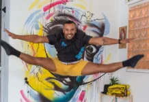 Novos editais da Aldir Blanc vão destinar R$ 1,8 milhão à cultura de São José Artista salta em frente a mural colorido, em imagem que ilustra os novos editais da Política Nacional Aldir Blanc em São José.