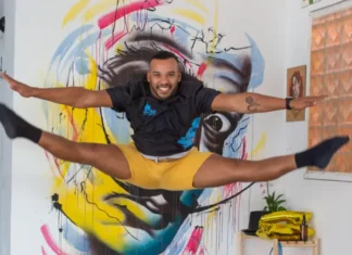 Artista salta em frente a mural colorido, em imagem que ilustra os novos editais da Política Nacional Aldir Blanc em São José.