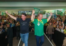 Em Santa Catarina, Flávio Bolsonaro defende redução de impostos e endurecimento contra o crime Flávio Bolsonaro e Jorginho Mello aparecem de mãos levantadas diante de apoiadores durante ato de campanha em Santa Catarina.
