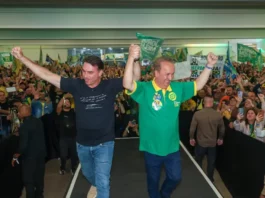 Em Santa Catarina, Flávio Bolsonaro defende redução de impostos e endurecimento contra o crime Flávio Bolsonaro e Jorginho Mello aparecem de mãos levantadas diante de apoiadores durante ato de campanha em Santa Catarina.