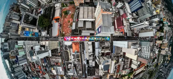 Vista aérea do Centro de Florianópolis, eleita a cidade mais criativa do Brasil, destaca prédios, ruas e intervenções de arte urbana, ilustrando a criatividade e a diversidade cultural da cidade.