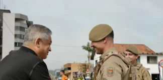 Candidato João Rodrigues cumprimentando policial militar