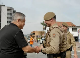 Candidato João Rodrigues cumprimentando policial militar