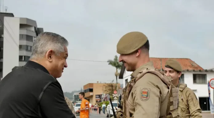Candidato João Rodrigues cumprimentando policial militar
