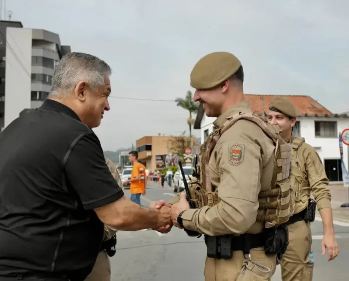 Candidato João Rodrigues cumprimentando policial militar