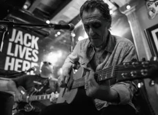 Músico toca guitarra durante apresentação de blues, imagem que ilustra o Praia do Rosa Blues Festival.