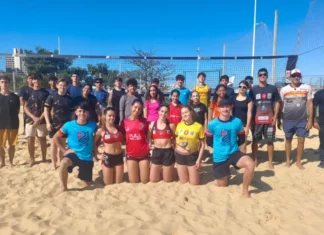 Projeto de vôlei de praia de São José revela talentos e ganha destaque nacional Jovens atletas e treinadores do projeto de vôlei de praia de São José posam em quadra de areia, representando a formação esportiva e o desenvolvimento de novos talentos no município.