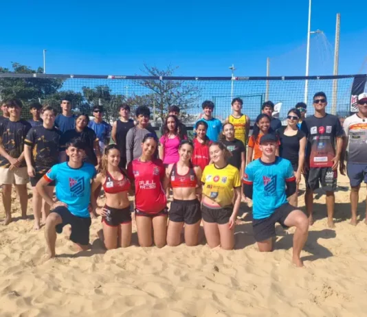 Projeto de vôlei de praia de São José revela talentos e ganha destaque nacional Jovens atletas e treinadores do projeto de vôlei de praia de São José posam em quadra de areia, representando a formação esportiva e o desenvolvimento de novos talentos no município.