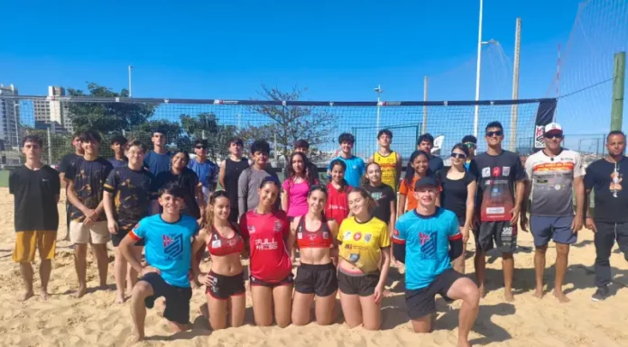 Projeto de vôlei de praia de São José revela talentos e ganha destaque nacional Jovens atletas e treinadores do projeto de vôlei de praia de São José posam em quadra de areia, representando a formação esportiva e o desenvolvimento de novos talentos no município.