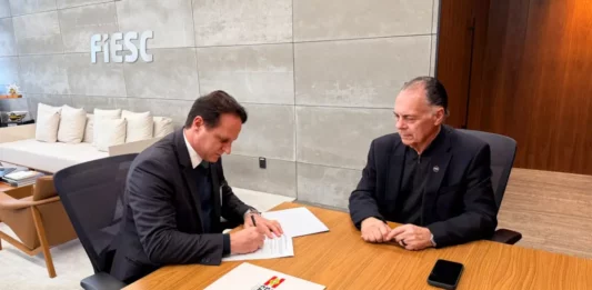 Estado e Fiesc ampliam estudos sobre transição energética em SC Secretário Guilherme Dallacosta assina acordo com o presidente da Fiesc, Gilberto Seleme, sobre transição energética em Santa Catarina
