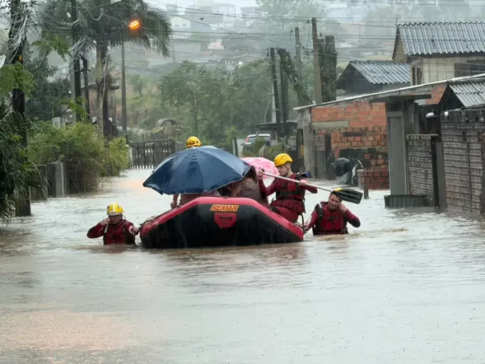 Bombeiros usam bote para resgatar moradores durante alagamentos em Criciúma.