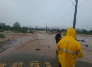 Alagamento toma via em Timbé do Sul durante as chuvas intensas, enquanto equipes acompanham a situação no município