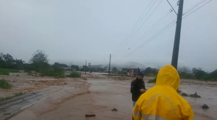 Alagamento toma via em Timbé do Sul durante as chuvas intensas, enquanto equipes acompanham a situação no município