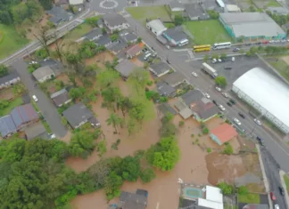 37 municípios registram ocorrências após chuvas e temporais; sete decretam emergência em SC Chuvas e temporais provocam alagamentos em área urbana, com água barrenta atingindo terrenos e residências próximas a uma via.
