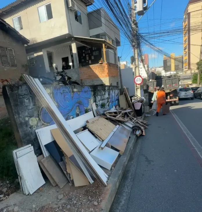 Móveis, madeiras e outros materiais em uma calçada de São José durante trabalho de recolhimento.