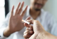 Texto alternativo: Pessoa segura um cigarro enquanto outra faz gesto de recusa, imagem que representa o tratamento para parar de fumar e o combate ao tabagismo.
