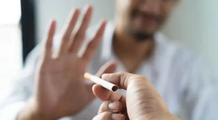 Texto alternativo: Pessoa segura um cigarro enquanto outra faz gesto de recusa, imagem que representa o tratamento para parar de fumar e o combate ao tabagismo.