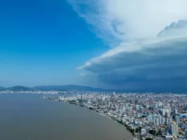 Semana terá mudança no tempo e aumento do risco de temporais em Santa Catarina Nuvens escuras de tempestade avançam sobre área urbana de Santa Catarina, imagem que ilustra o aumento do risco de temporais no estado.