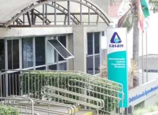 Casan prorroga inscrições de concurso com remuneração que pode passar de R$ 14 mil Fachada da sede administrativa da Casan, em Florianópolis, com entrada de vidro, rampa de acesso e placa de identificação da companhia