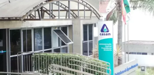Casan prorroga inscrições de concurso com remuneração que pode passar de R$ 14 mil Fachada da sede administrativa da Casan, em Florianópolis, com entrada de vidro, rampa de acesso e placa de identificação da companhia