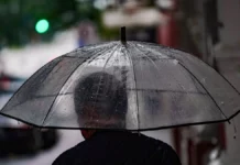 Frio dá lugar à chuva e temporais na última semana de outubro em Santa Catarina Pessoa caminha com guarda-chuva em rua molhada, ilustrando a previsão de chuva e temporais em Santa Catarina.