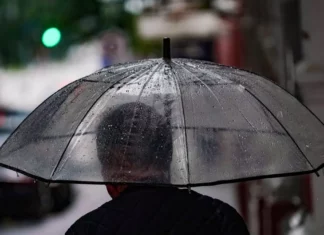 Frio dá lugar à chuva e temporais na última semana de outubro em Santa Catarina Pessoa caminha com guarda-chuva em rua molhada, ilustrando a previsão de chuva e temporais em Santa Catarina.