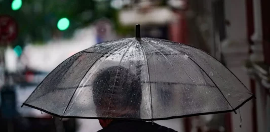 Frio dá lugar à chuva e temporais na última semana de outubro em Santa Catarina Pessoa caminha com guarda-chuva em rua molhada, ilustrando a previsão de chuva e temporais em Santa Catarina.