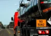 Caminhão-tanque com placas de identificação de produtos perigosos trafega por rodovia, ilustrando os riscos abordados no curso gratuito da Defesa Civil de SC.
