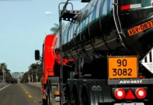 Caminhão-tanque com placas de identificação de produtos perigosos trafega por rodovia, ilustrando os riscos abordados no curso gratuito da Defesa Civil de SC.