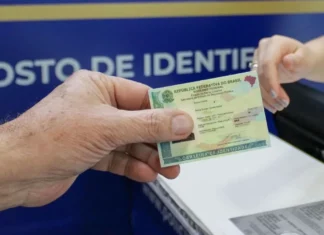 Pessoa apresenta carteira de identidade em um posto de identificação de Santa Catarina. Imagem ilustra a emissão de 3 milhões de Carteiras de Identidade Nacional no estado.