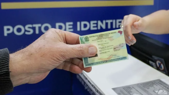 Pessoa apresenta carteira de identidade em um posto de identificação de Santa Catarina. Imagem ilustra a emissão de 3 milhões de Carteiras de Identidade Nacional no estado.