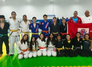 Equipe de jiu-jítsu de São José posa com treinadores e bandeira do município durante a Olesc 2026.