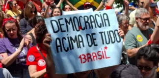 Manifestantes com bandeiras de apoio a Lula e cartaz em defesa da democracia durante o ato Mulheres com Lula, no Centro de Florianópolis, neste sábado (17).