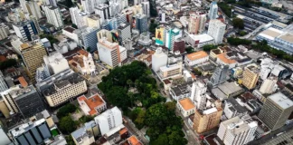Vista aérea do Centro de Florianópolis, com prédios, ruas e áreas arborizadas, ilustrando os desafios do trânsito e transporte na Capital e a discussão sobre mobilidade urbana.