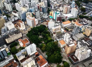 Vista aérea do Centro de Florianópolis, com prédios, ruas e áreas arborizadas, ilustrando os desafios do trânsito e transporte na Capital e a discussão sobre mobilidade urbana.