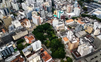 Vista aérea do Centro de Florianópolis, com prédios, ruas e áreas arborizadas, ilustrando os desafios do trânsito e transporte na Capital e a discussão sobre mobilidade urbana.