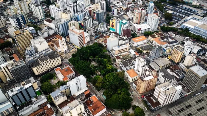 Vista aérea do Centro de Florianópolis, com prédios, ruas e áreas arborizadas, ilustrando os desafios do trânsito e transporte na Capital e a discussão sobre mobilidade urbana.