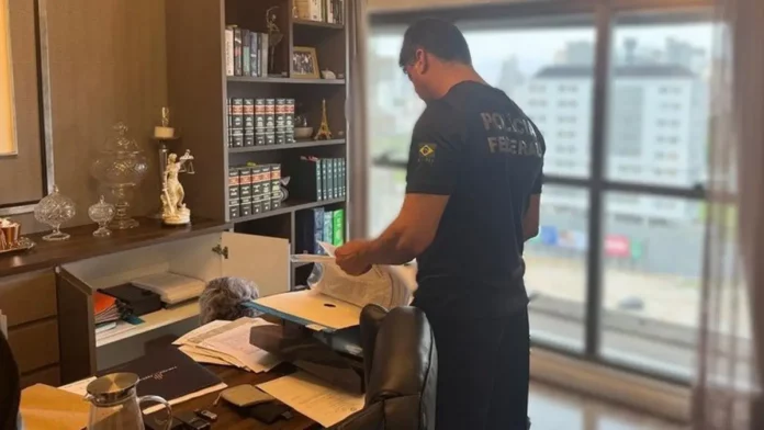 pf-operacao-palhoca Agente da Polícia Federal examina documentos durante operação que investiga irregularidades na previdência dos servidores de Palhoça, em Santa Catarina.