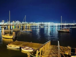 São José recebe 1ª Regata Plínio Verani de Veleiros de Oceano Veleiros ancorados à noite na Baía Sul, com luzes da cidade refletidas na água. Imagem ilustra a 1ª Regata Plínio Verani de Veleiros de Oceano, em São José.