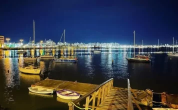 São José recebe 1ª Regata Plínio Verani de Veleiros de Oceano Veleiros ancorados à noite na Baía Sul, com luzes da cidade refletidas na água. Imagem ilustra a 1ª Regata Plínio Verani de Veleiros de Oceano, em São José.