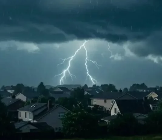 Raios iluminam o céu durante temporal com chuva e nuvens carregadas sobre uma área residencial, ilustrando o risco de tempestades em Santa Catarina.