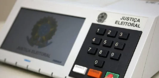 STF prorroga votação até as 19h e TSE suspende divulgação dos resultados Eleitor pressiona a tecla confirma de uma urna eletrônica, em imagem que ilustra a suspensão da divulgação dos resultados das eleições pelo TSE após decisão do STF.