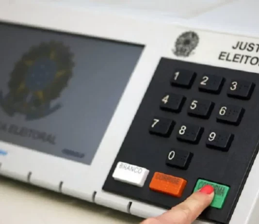 STF prorroga votação até as 19h e TSE suspende divulgação dos resultados Eleitor pressiona a tecla confirma de uma urna eletrônica, em imagem que ilustra a suspensão da divulgação dos resultados das eleições pelo TSE após decisão do STF.